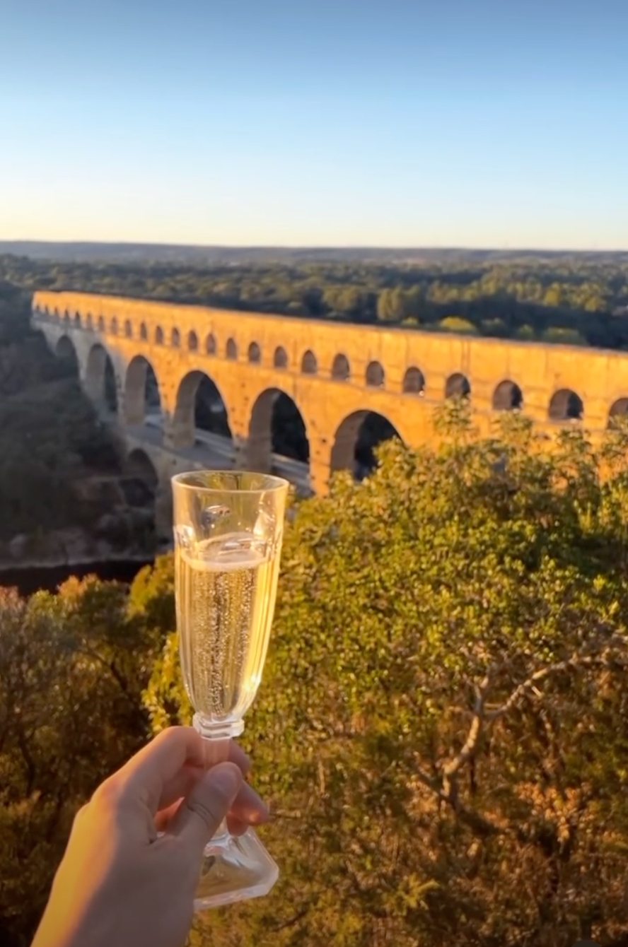Champagne overlooking the Pont du Gard at golden hour