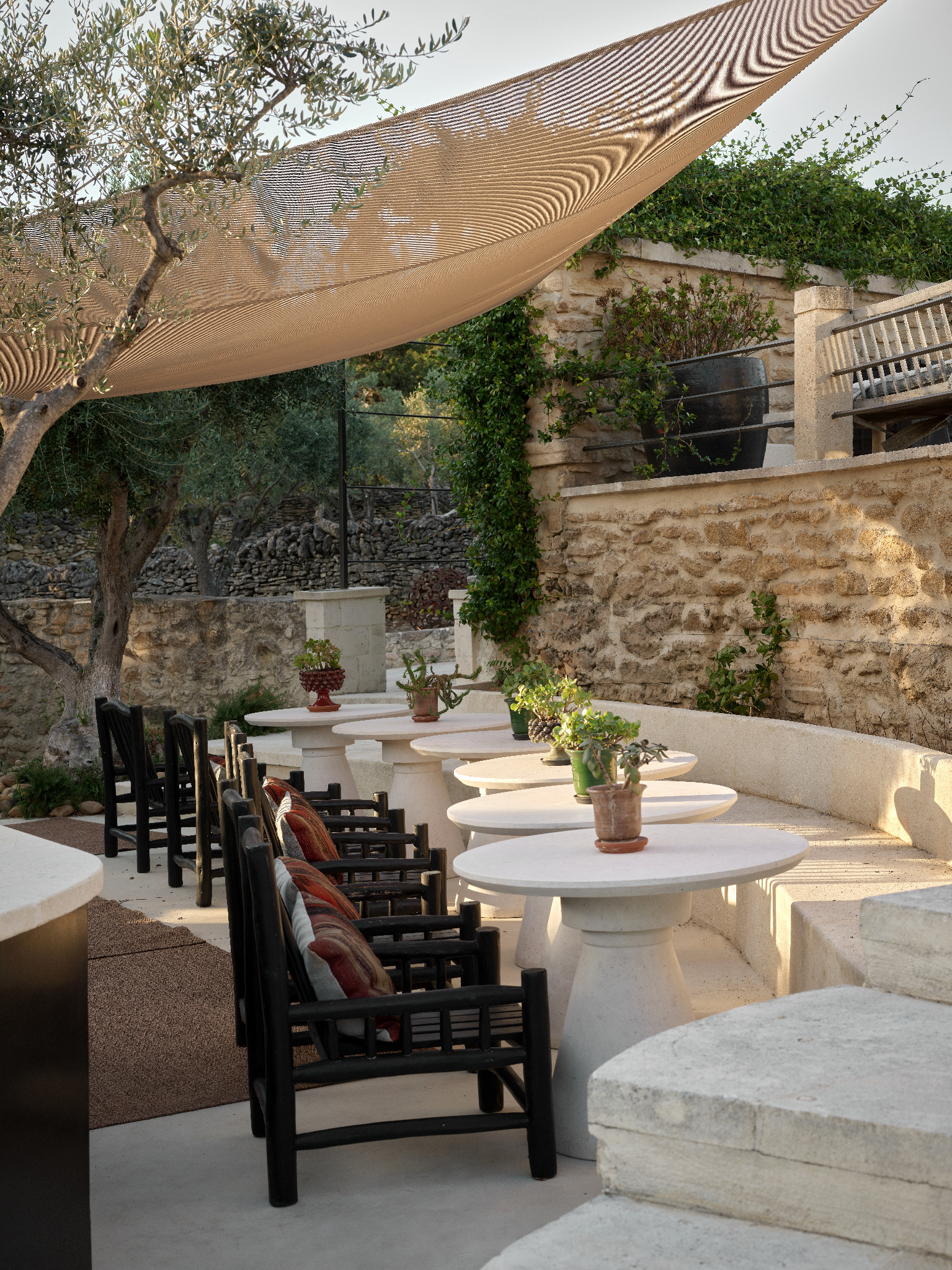 Shaded terrace with white tables and black chairs