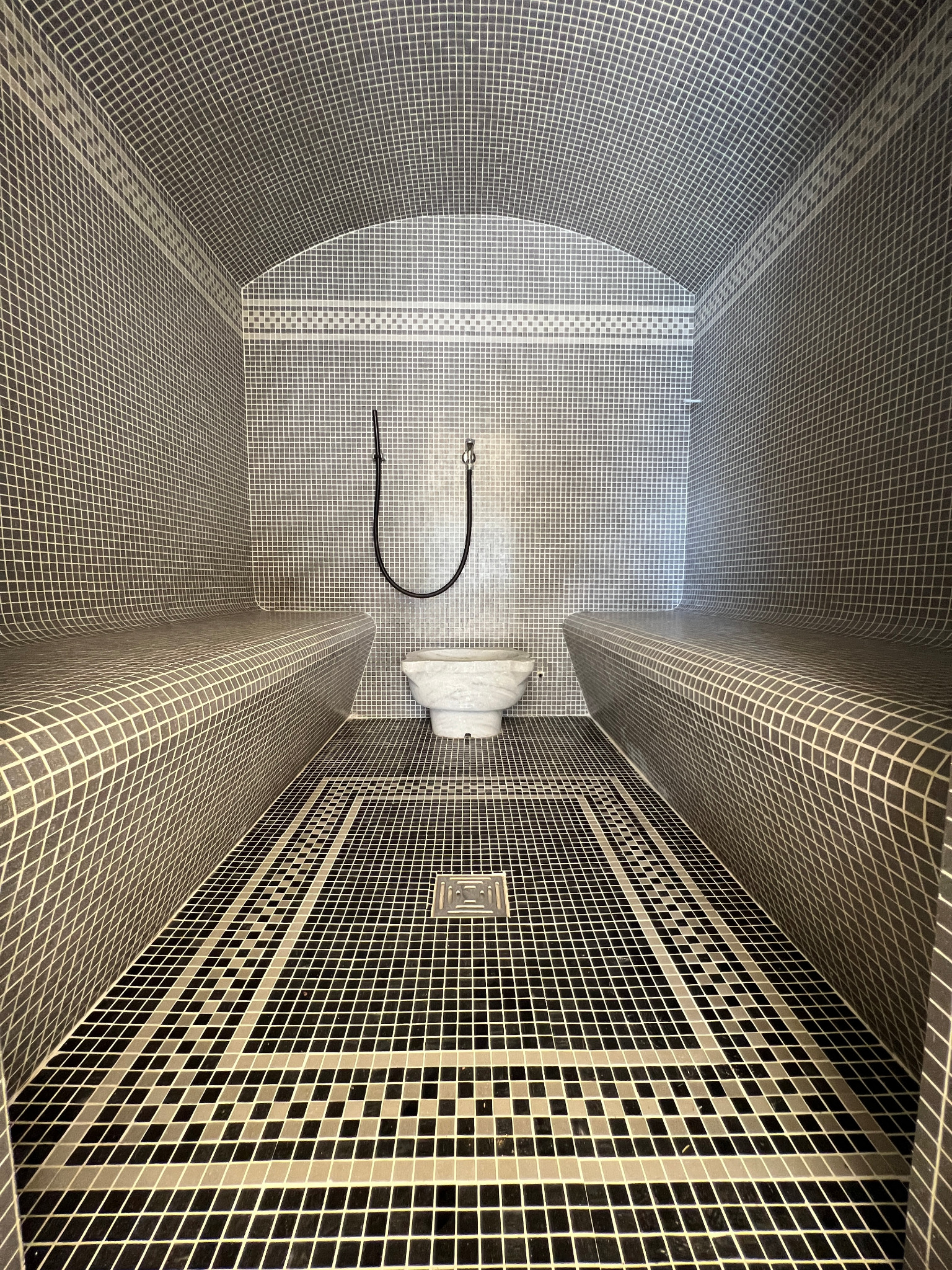 Private hammam with mosaic tiles and stone benches