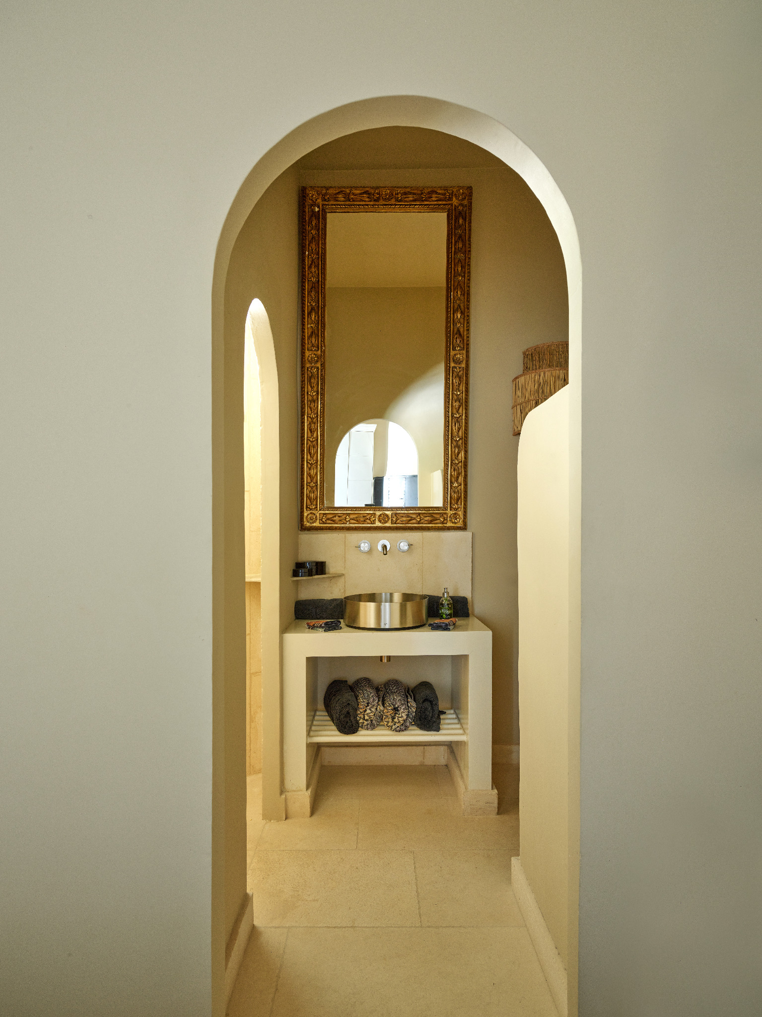 Private bathroom with gold mirror and brass basin